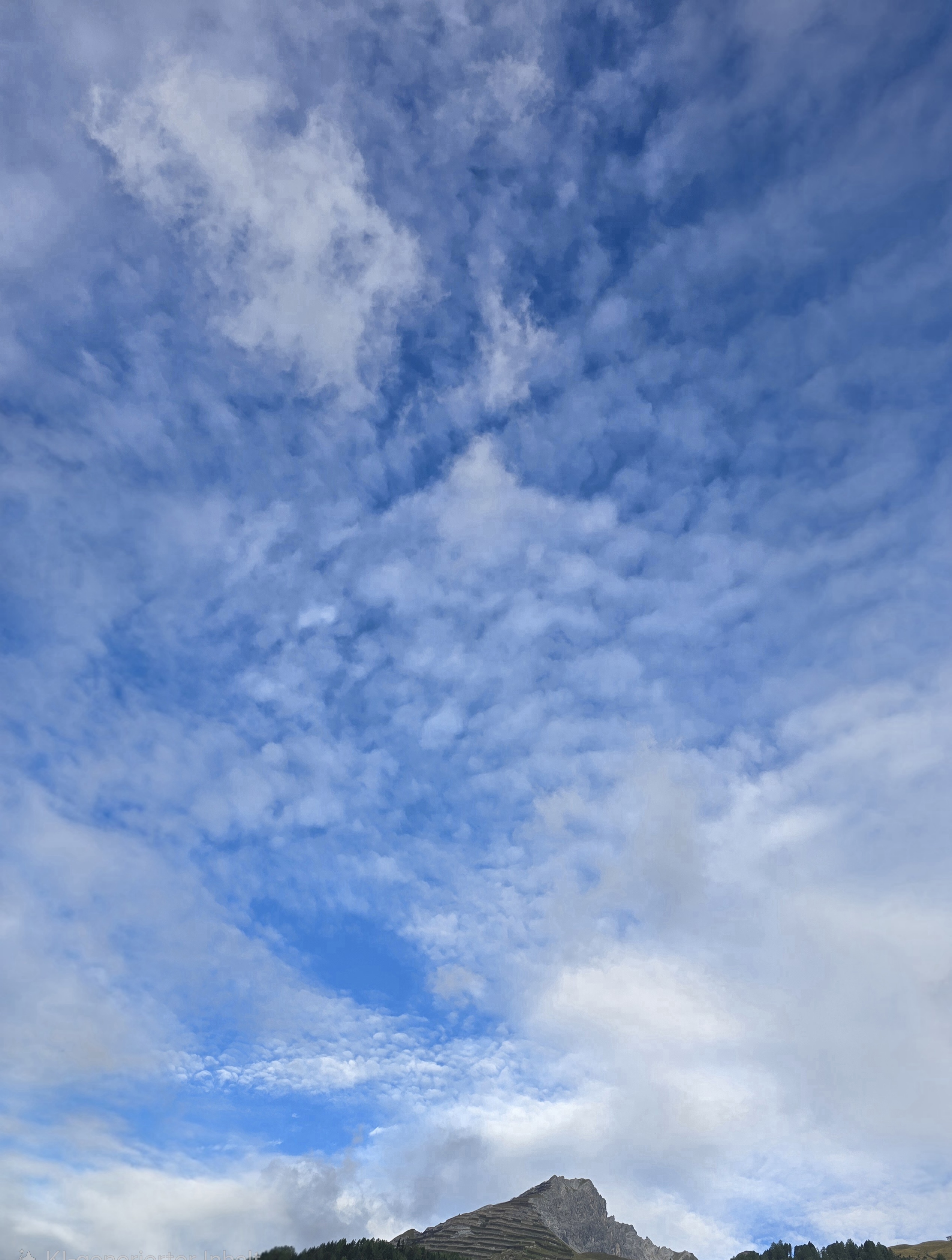 Zwischen lockeren Wolkenfeldern ist deutlich mehr Blau zu sehen. Kleine Wolkentupfen bilden feine Muster.
